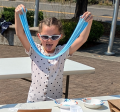Photo of child playing with blue slime they made at the Library.