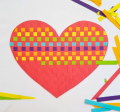 Photo of red heart decorated with multi-colored strips of paper woven through it.