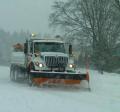 Snow plowing down snowy street