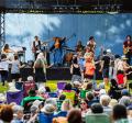 photo of a crowd at a concert with performers on stage