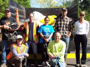 Volunteers standing in front of dump truck filled with litter.