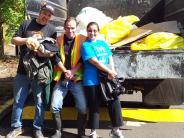Volunteers standing in front of dump truck filled with litter.