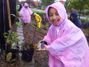 Girl planint in a pink poncho