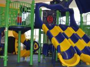 A large indoor play structure with multiple slides at Outdoors In
