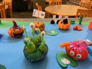 Shrunken Regatta decorated mini pumpkins on a blue paper lake
