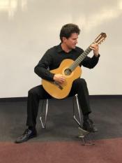 Peter Fletcher playing an acoustic guitar