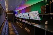 Photo of GameTruck interior with video games on multiple widescreen monitors