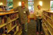 Father and daughter polishing shelves and books