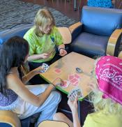 Teens playing a card game around a table Teens playing a card game around a table