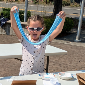 Photo of child playing with blue slime they made at the Library.