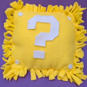 Photo of square yellow pillow made from fleece. 