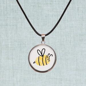 Photo of necklace pendant made from a yellow fingerprint, that looks like a bee.