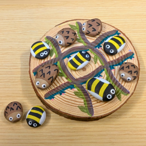 tic-tac-toe game made from slice of tree and painted rocks.