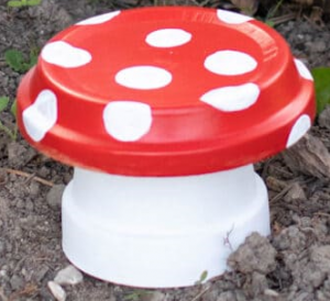 red and white mushroom made from clay pots and saucer.