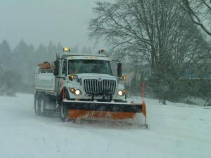 Snow plowing down snowy street