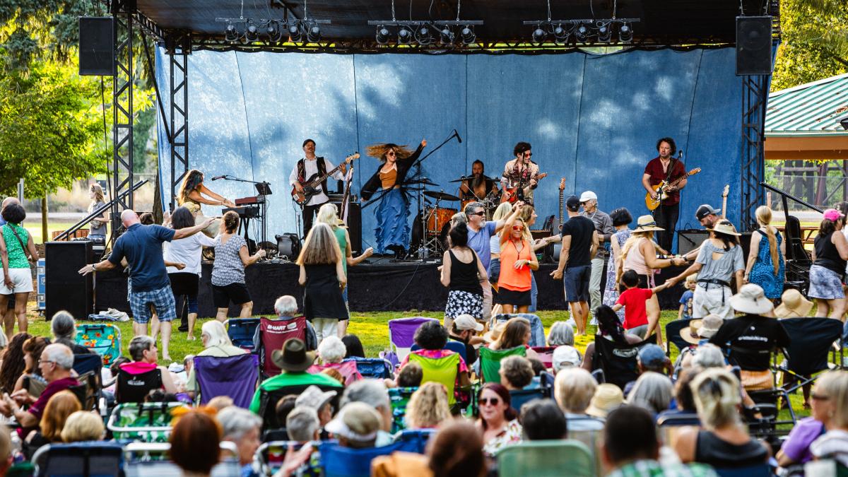 photo of a crowd at a concert with performers on stage